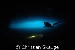A diver in one of the caves on the west coast of the isla... by Christian Skauge 